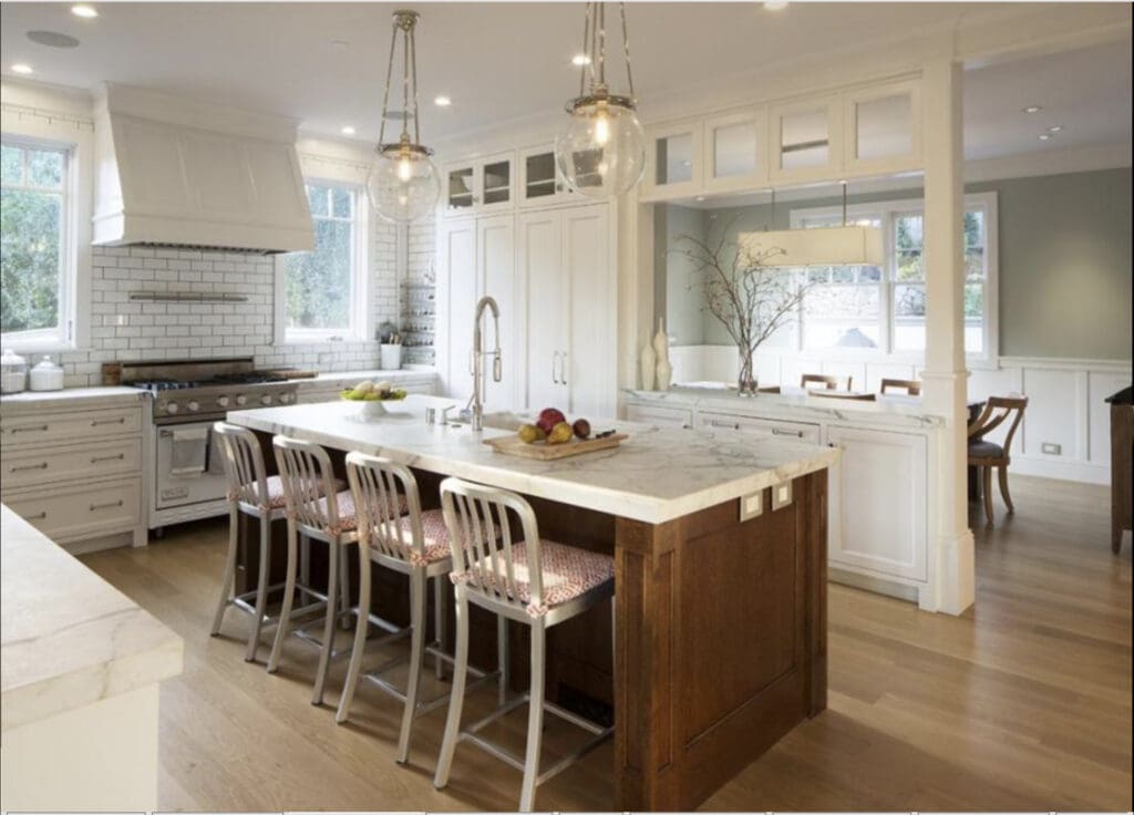 Light-filled San Anselmo kitchen designed with a restorative approach, featuring a marble island with integrated seating, custom cabinetry, soft neutral finishes, and an open layout that supports ease, gathering, and daily rhythm.