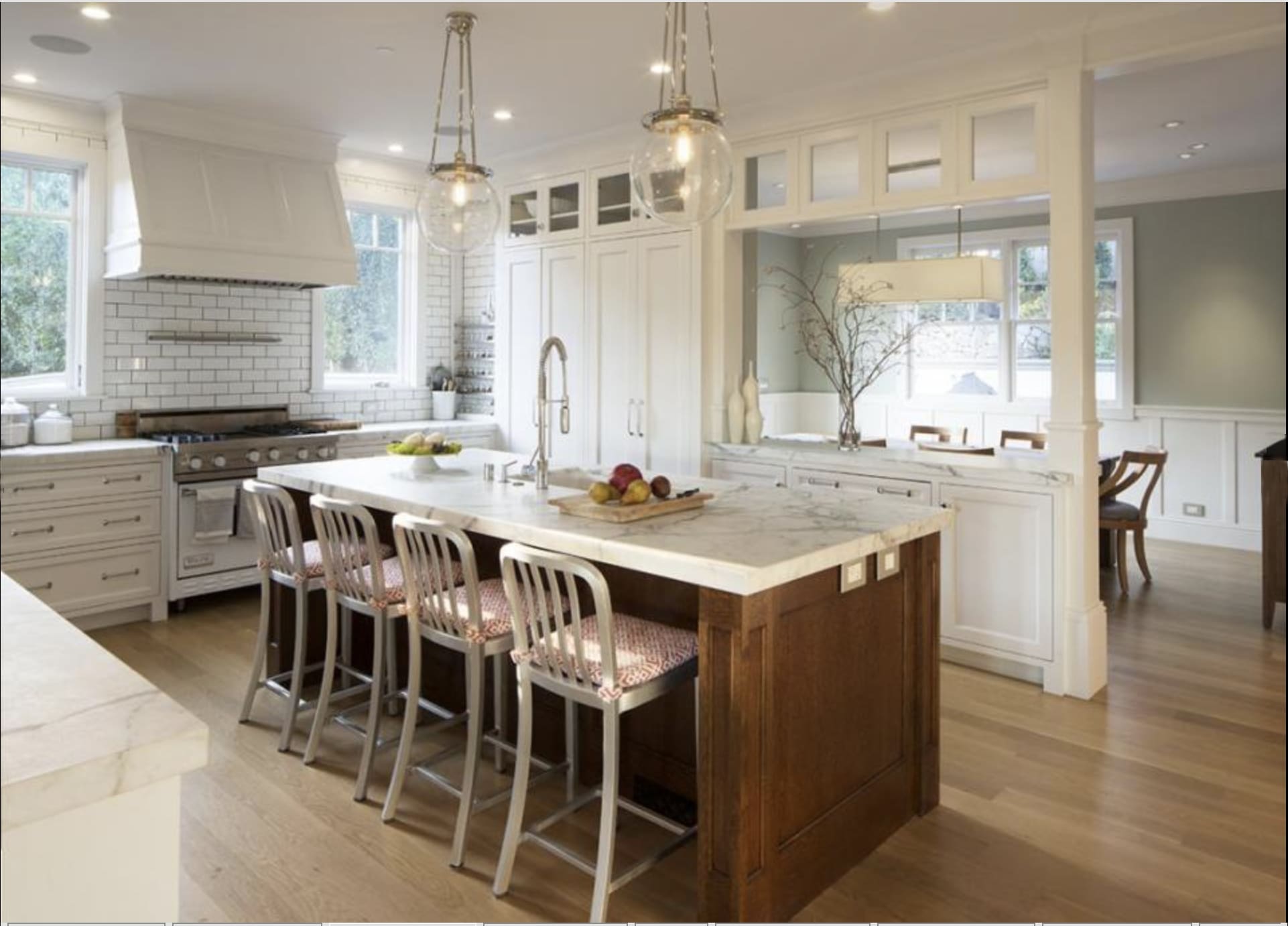 Light-filled San Anselmo kitchen designed with a restorative approach, featuring a marble island with integrated seating, custom cabinetry, soft neutral finishes, and an open layout that supports ease, gathering, and daily rhythm.